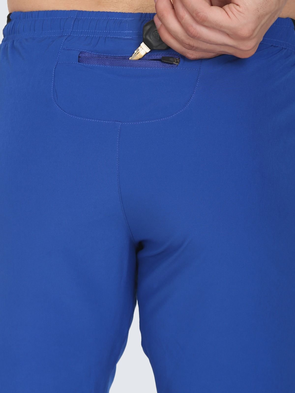 Close-up of back waistband showing zip pocket with key tucked inside on royal blue Knitted Mesh shorts
