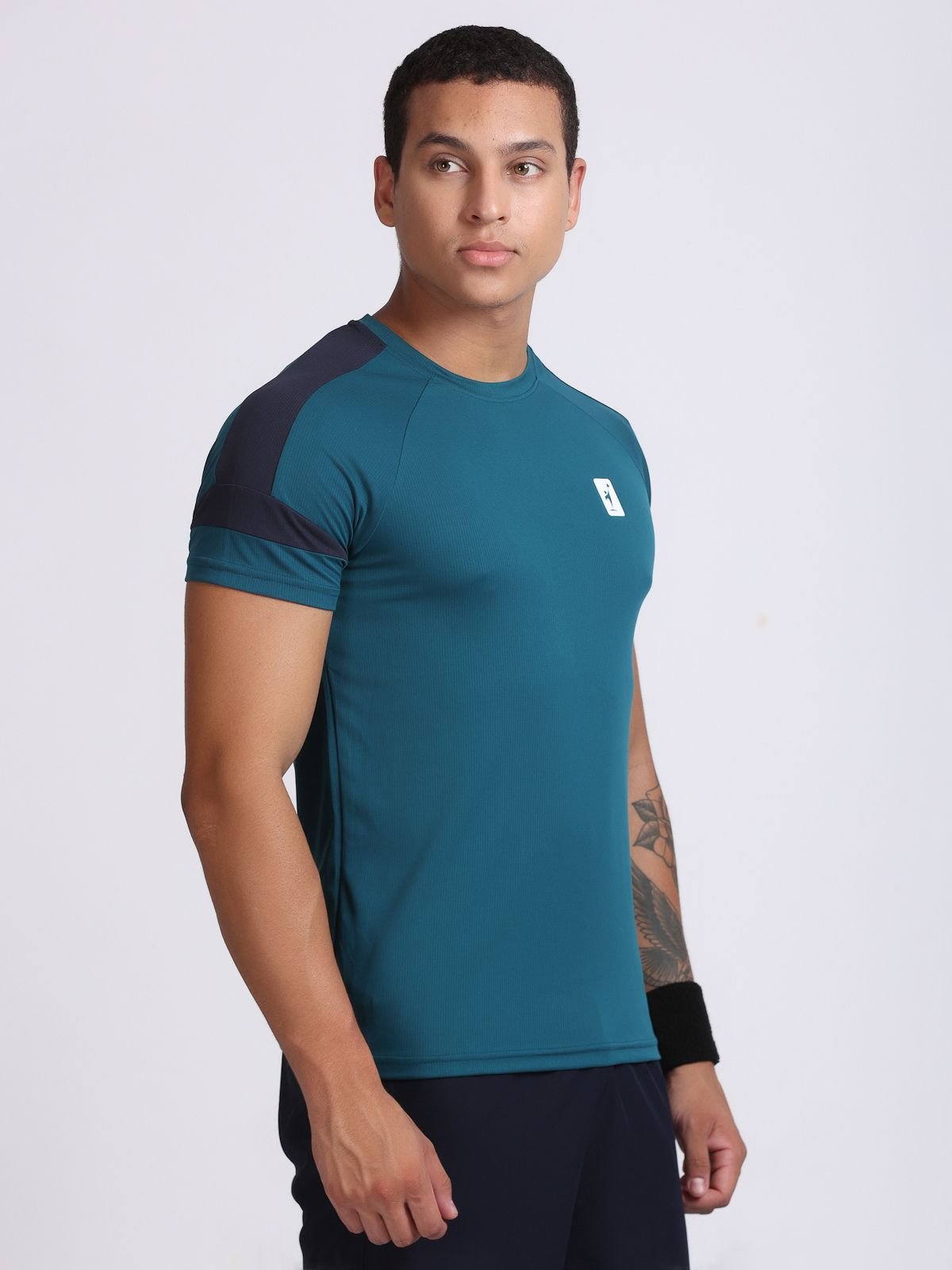 Front three-quarter view of a man wearing a teal athletic AirFeel t-shirt.
