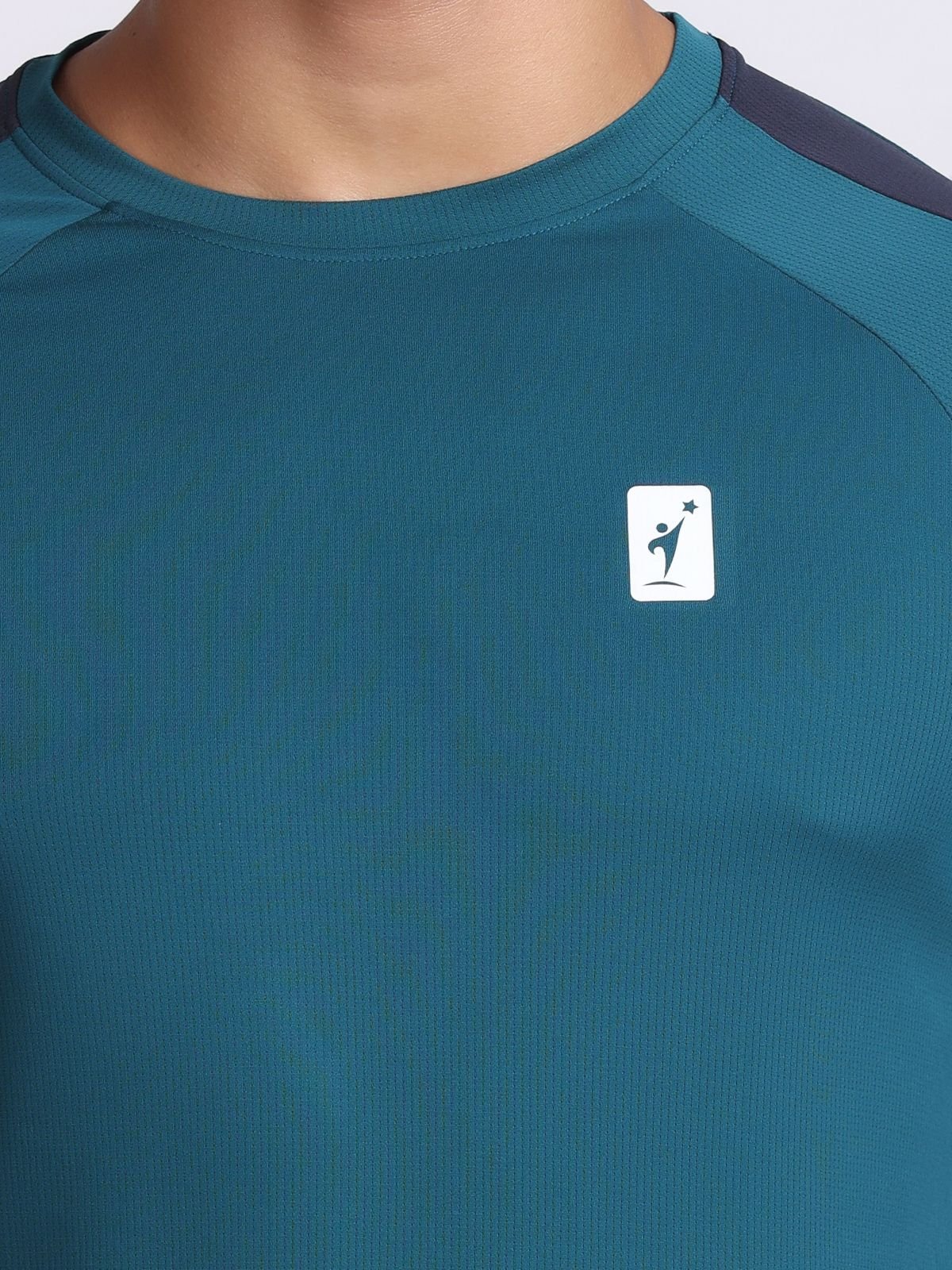 Close-up of the chest brand logo of NDR SPORT on a teal athletic t-shirt AirFeel.