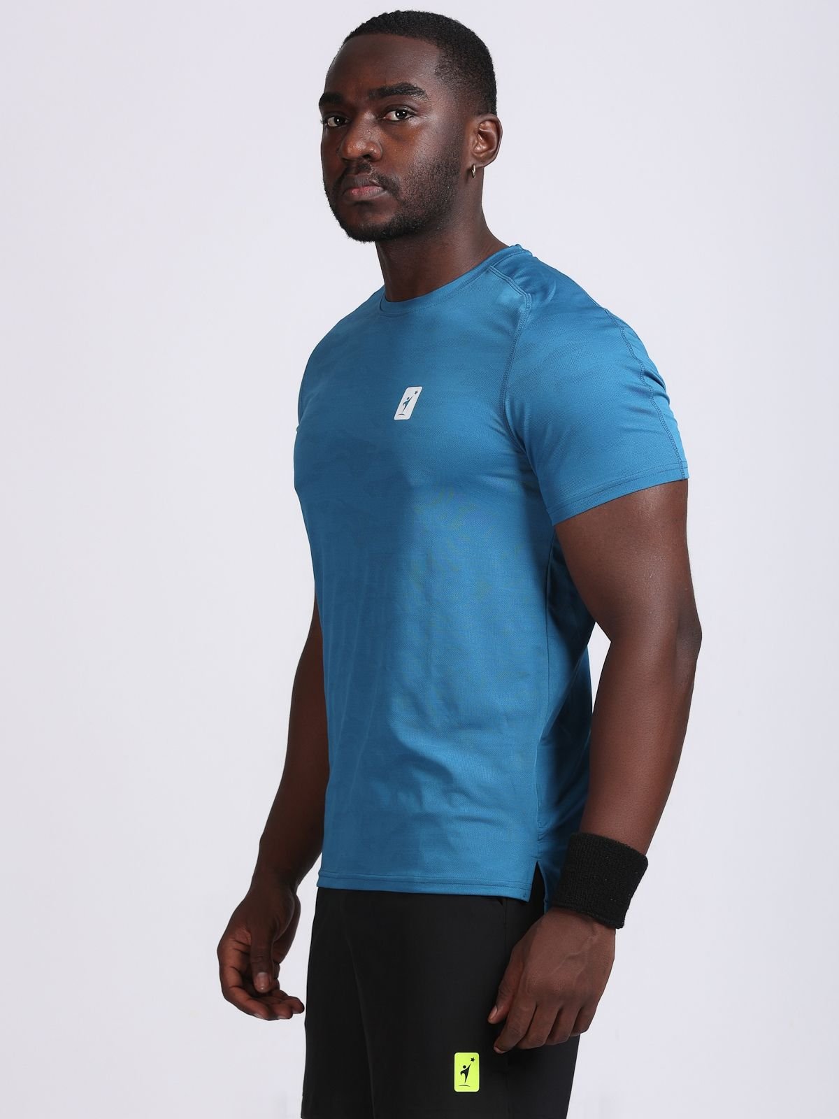 Side view of a man wearing a teal JaqMesh athletic t-shirt.