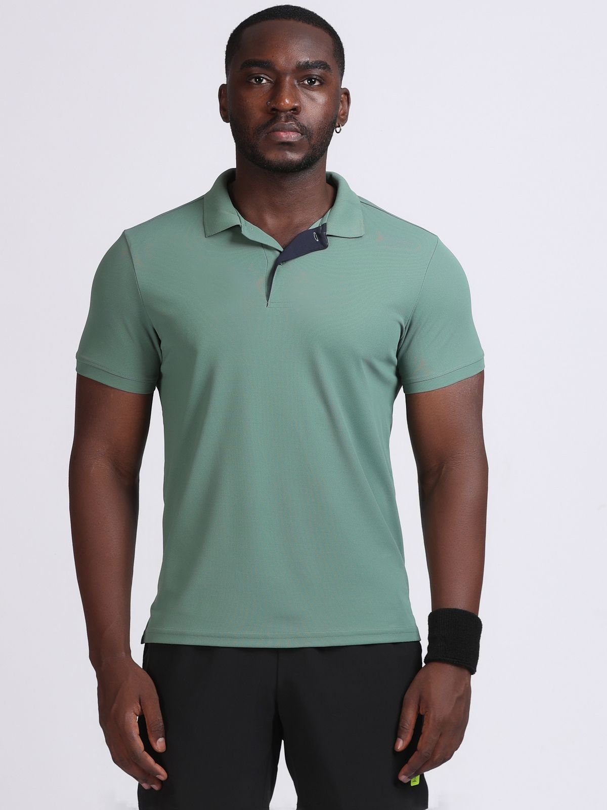 Front view of a model wearing a bottle green Solid polo t-shirt with a dark contrast inner placket.