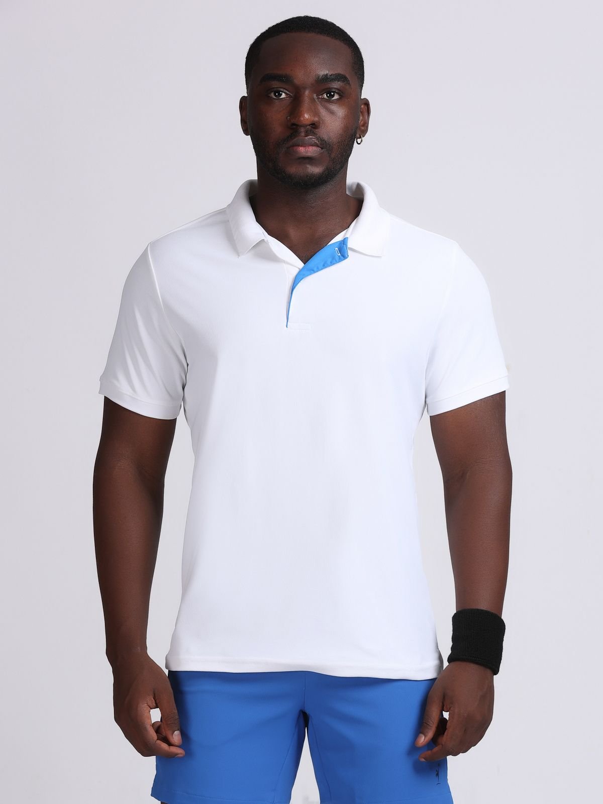 Front view of a model wearing a white polo Solid t-shirt with a bright blue contrast inner placket.